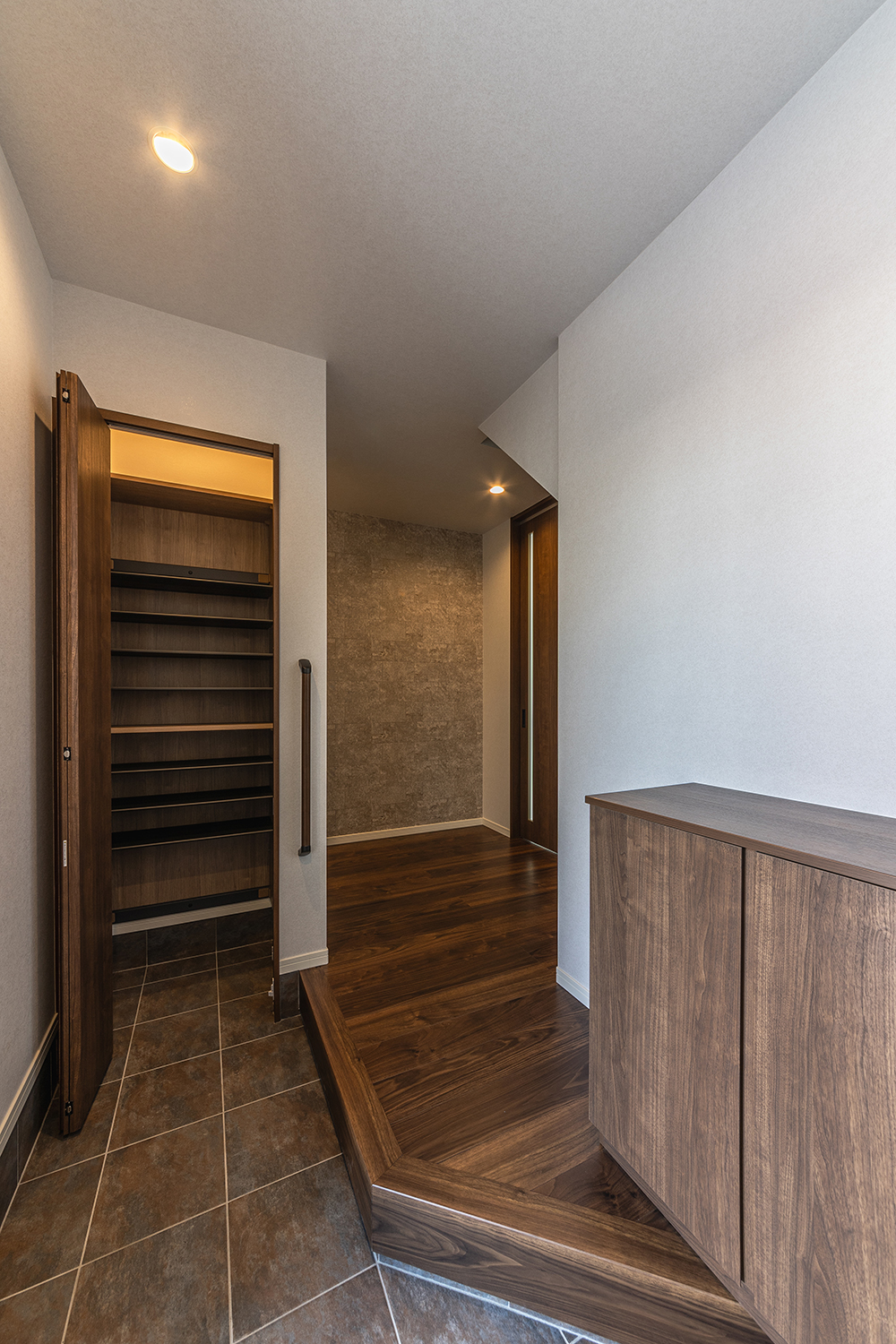 T-3/独特の風合いが高級感を演出する玄関は、ダークカラーのコントラストが落ち着いた印象。