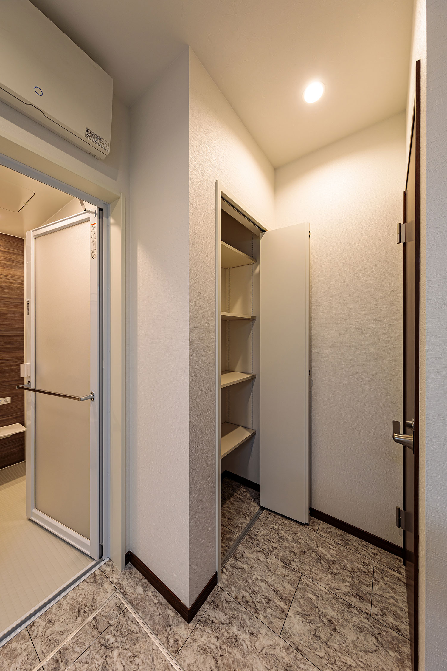 T-3／脱衣室には整理整頓しやすい可動棚付きの物入れを設置。高さが変えられるので、スペースを無駄なく利用可能。