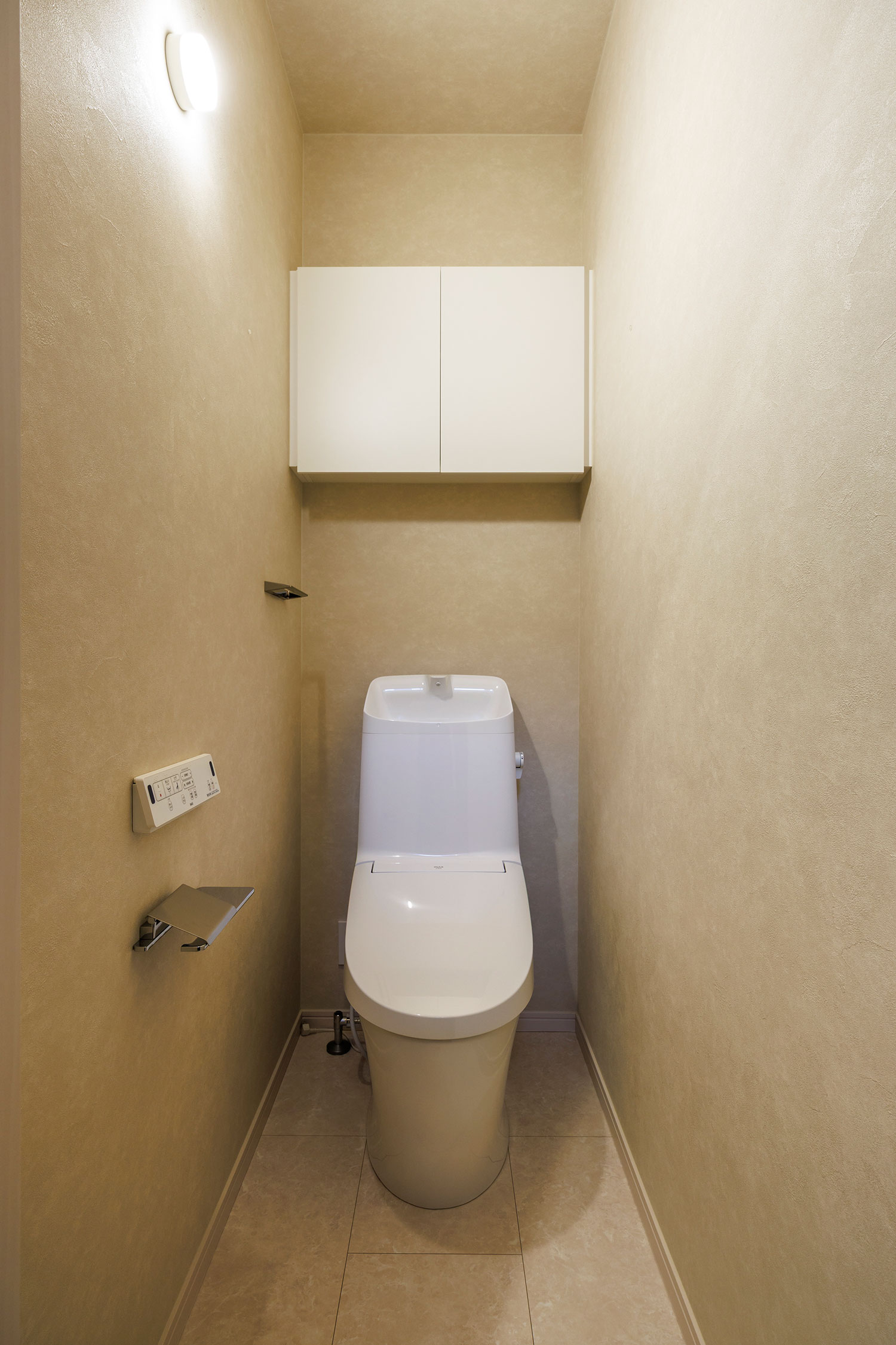 T-1／優しいカラーでゆったりと過ごせるトイレ空間。1階・2階とも、上部に吊収納を設置しています。