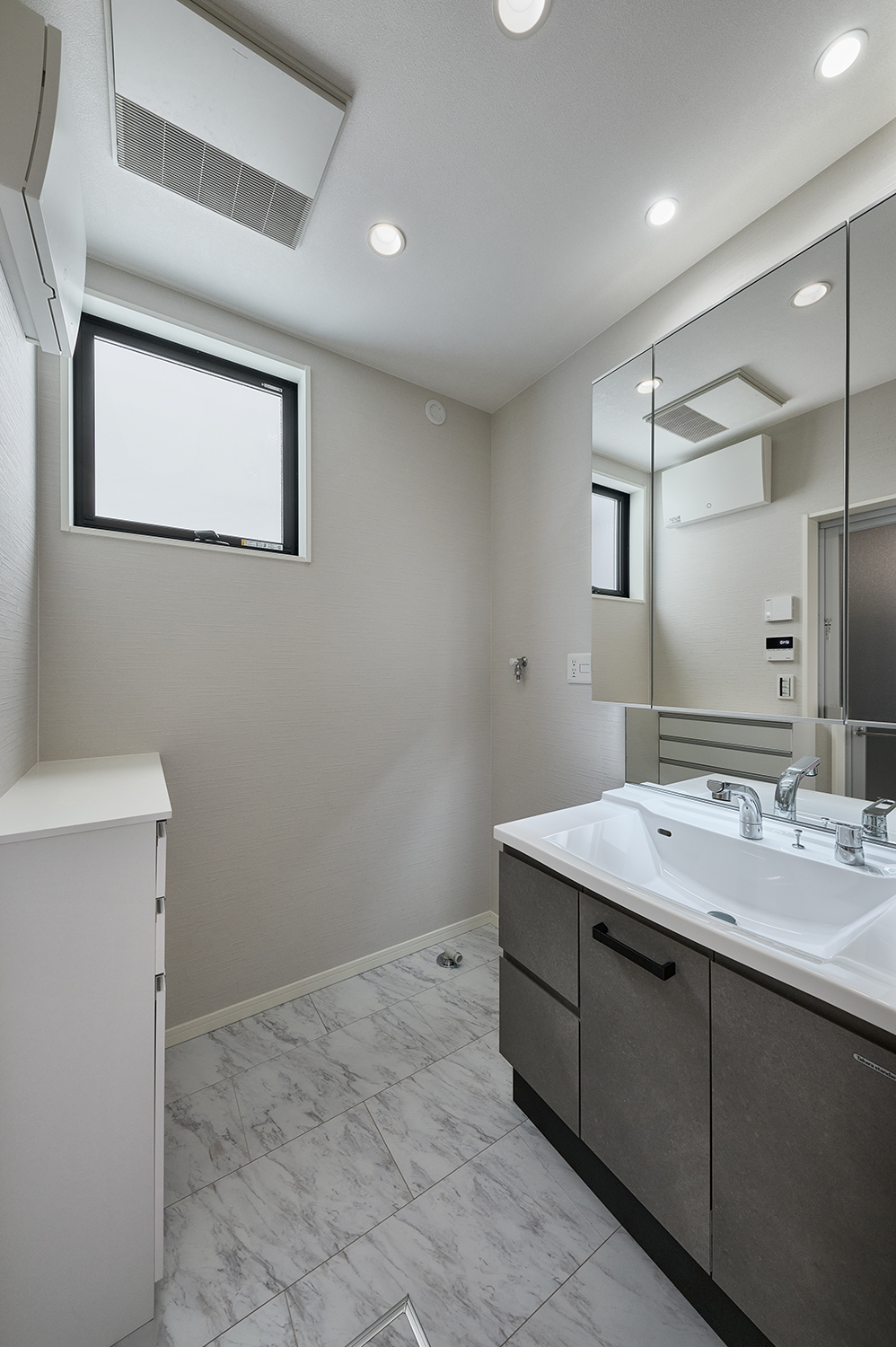 T-5／明るく清潔感のある洗面脱衣室には、薄型ランドリーキャビネットを備えており、タオルなどをすっきり収納。