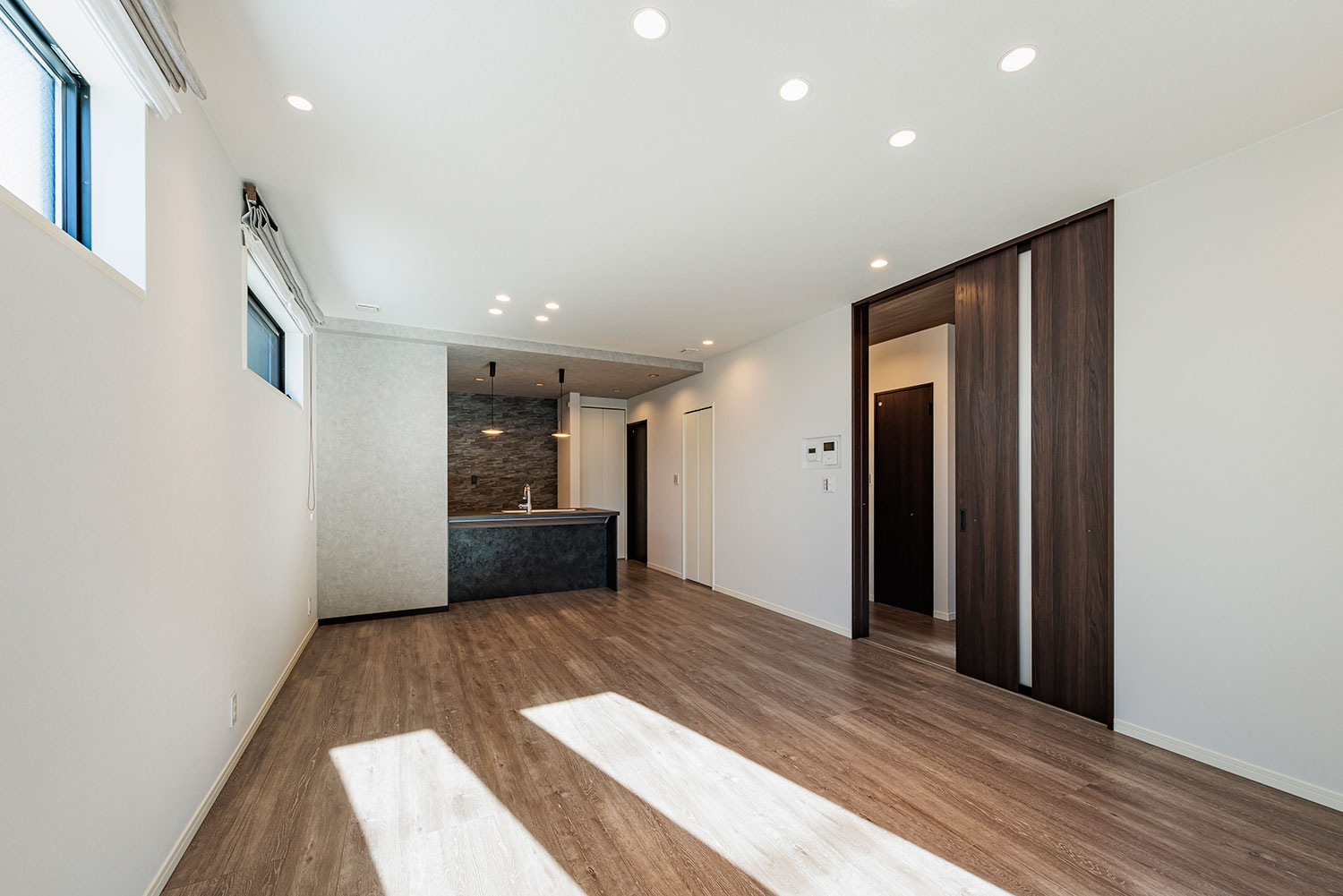 T-4/白を基調とした明るいLDK。木目の床が空間に温もりを添え、対面キッチンで家族の会話も自然と弾みます。