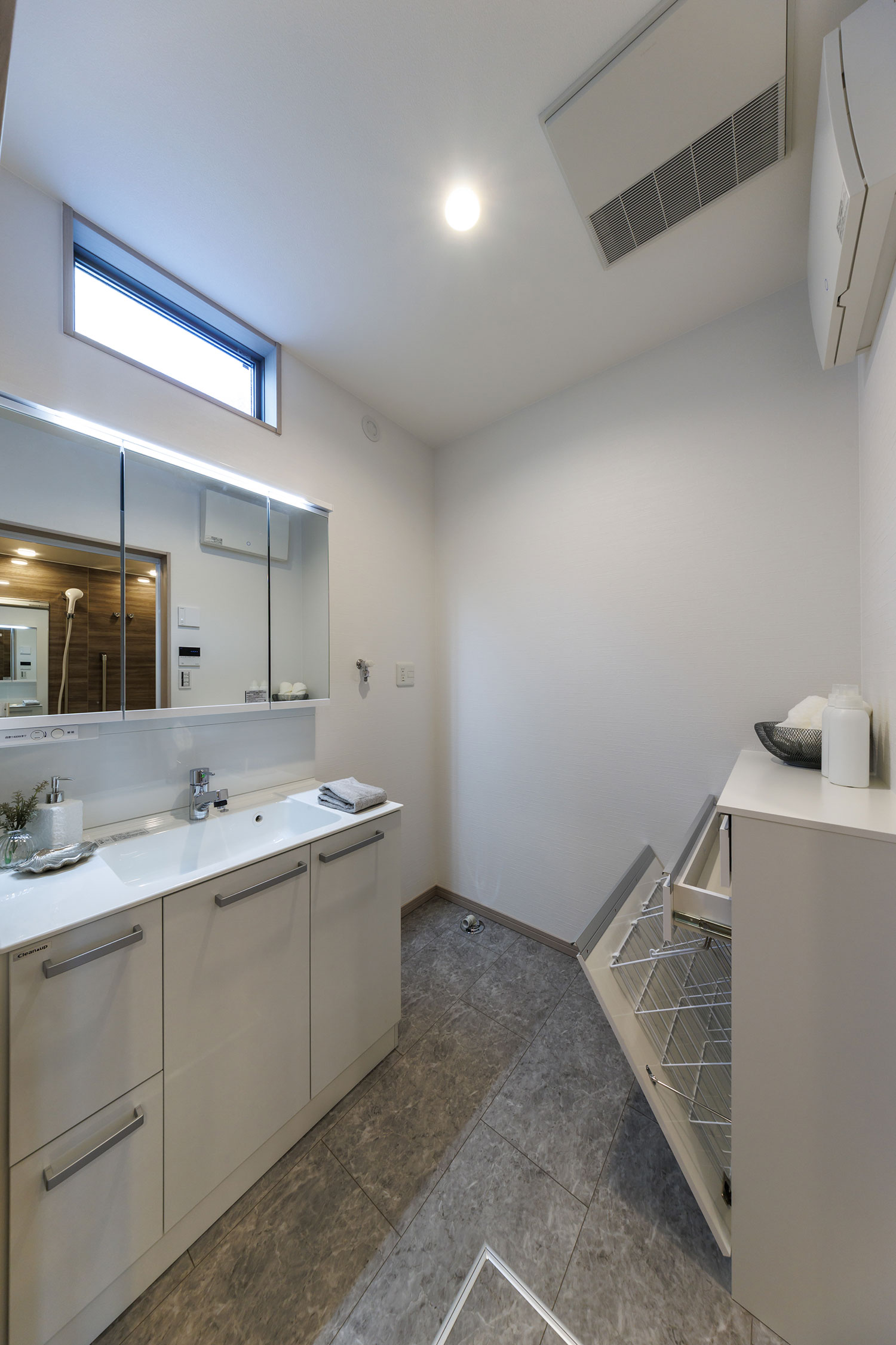 T-1／明るい自然光が爽やかな洗面室。鏡面収納とランドリーキャビネットで収納力を持たせ、水回りをスッキリと。