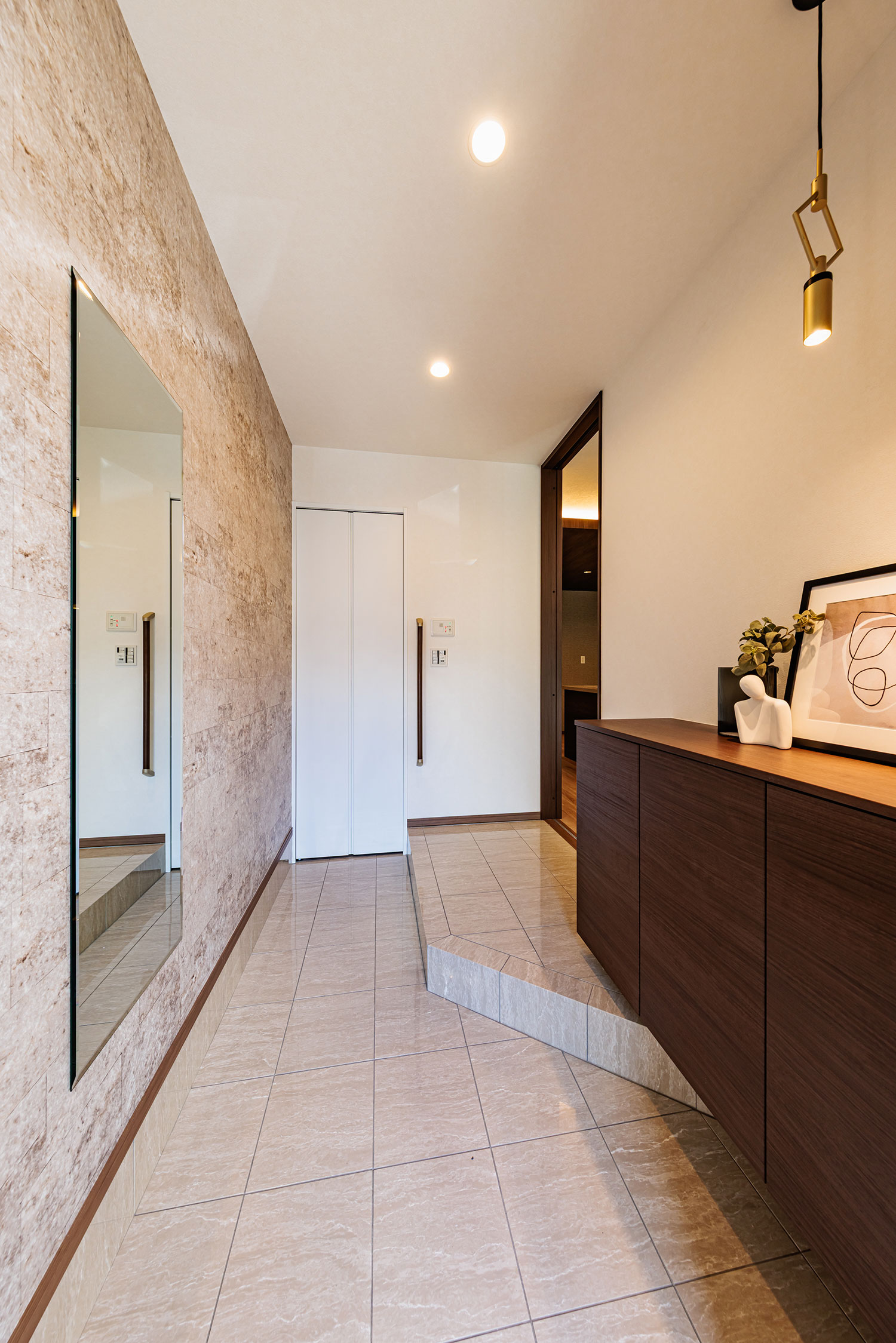 T-2／ダルブラウンのシューズボックスに淡いベージュの鏡面タイルが洗練された美しさで訪れる人を迎え入れます。