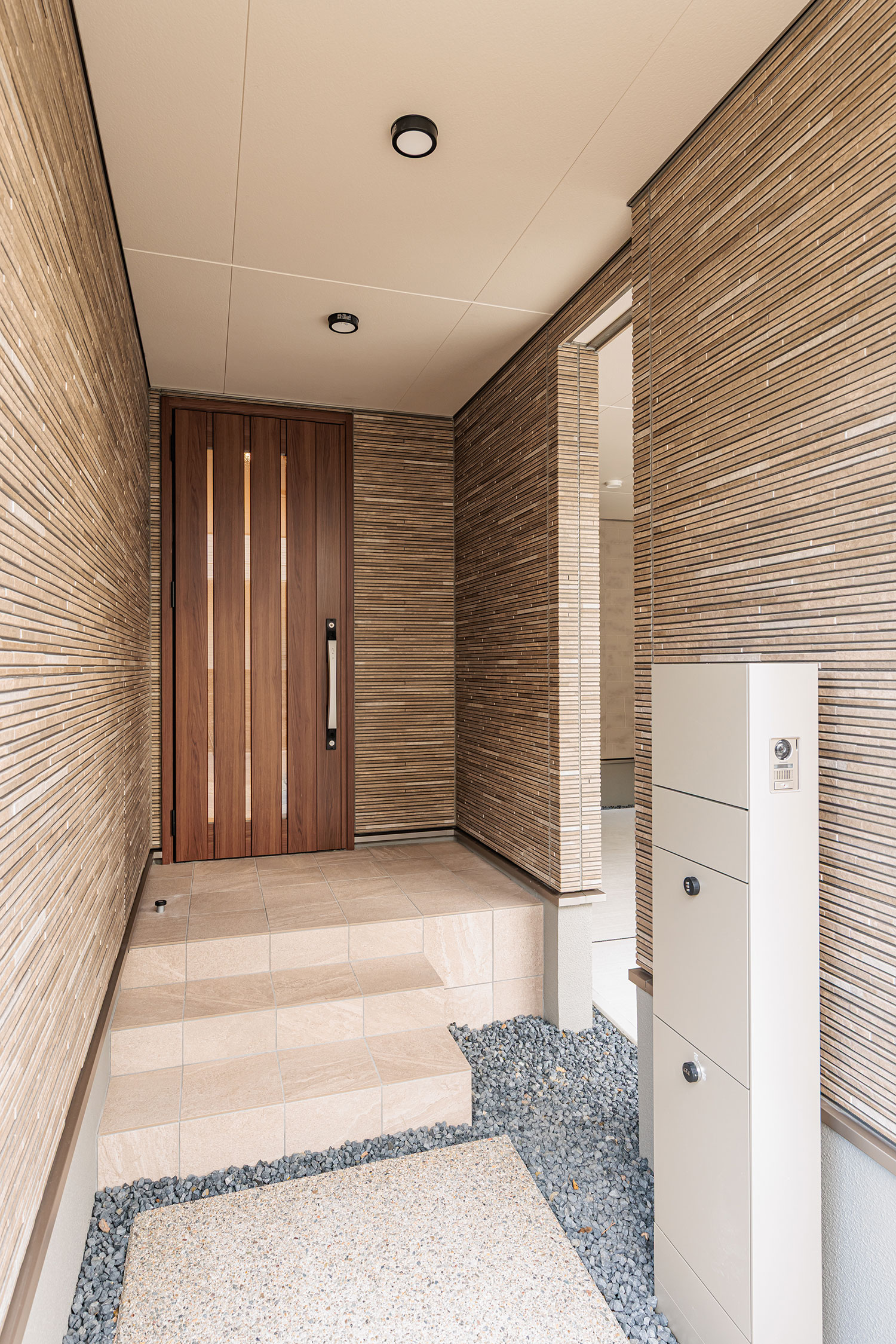 T-1/雨の日も快適な深めのポーチと、宅配ボックスを備えた玄関。ドアには「FamiLock」搭載で防犯性にも配慮。